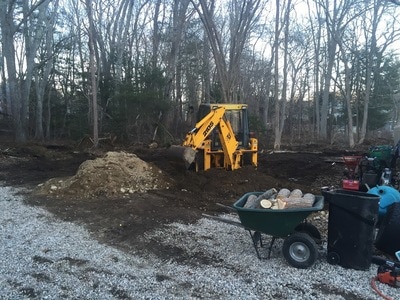 Backhoe yard and tree log clean out